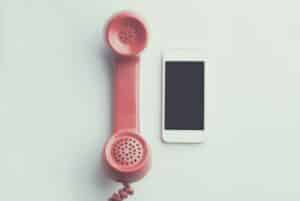 A classic pink handset sits besides an old smartphone.