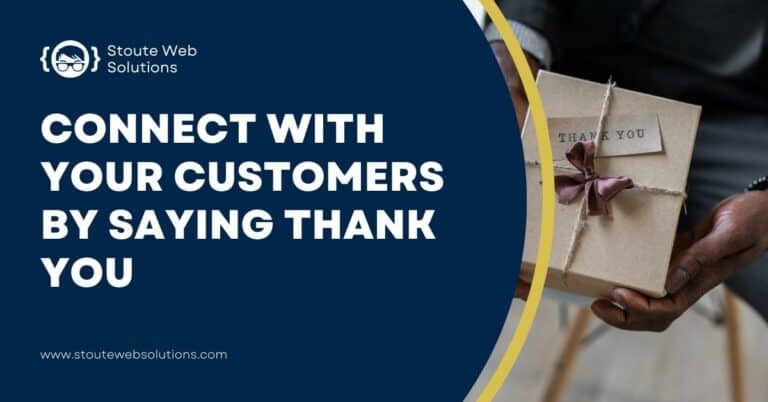 A man in a suit holds a small box with a thank you card on top.