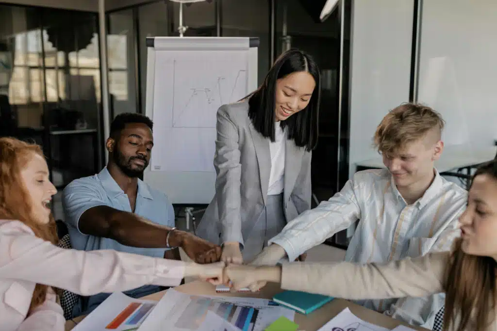 A Group Of People Having Fist Bump In The Office